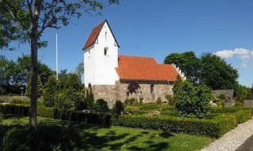 Hvid kirke med rødt tag og en blå himmel som er Tapdrup kirke